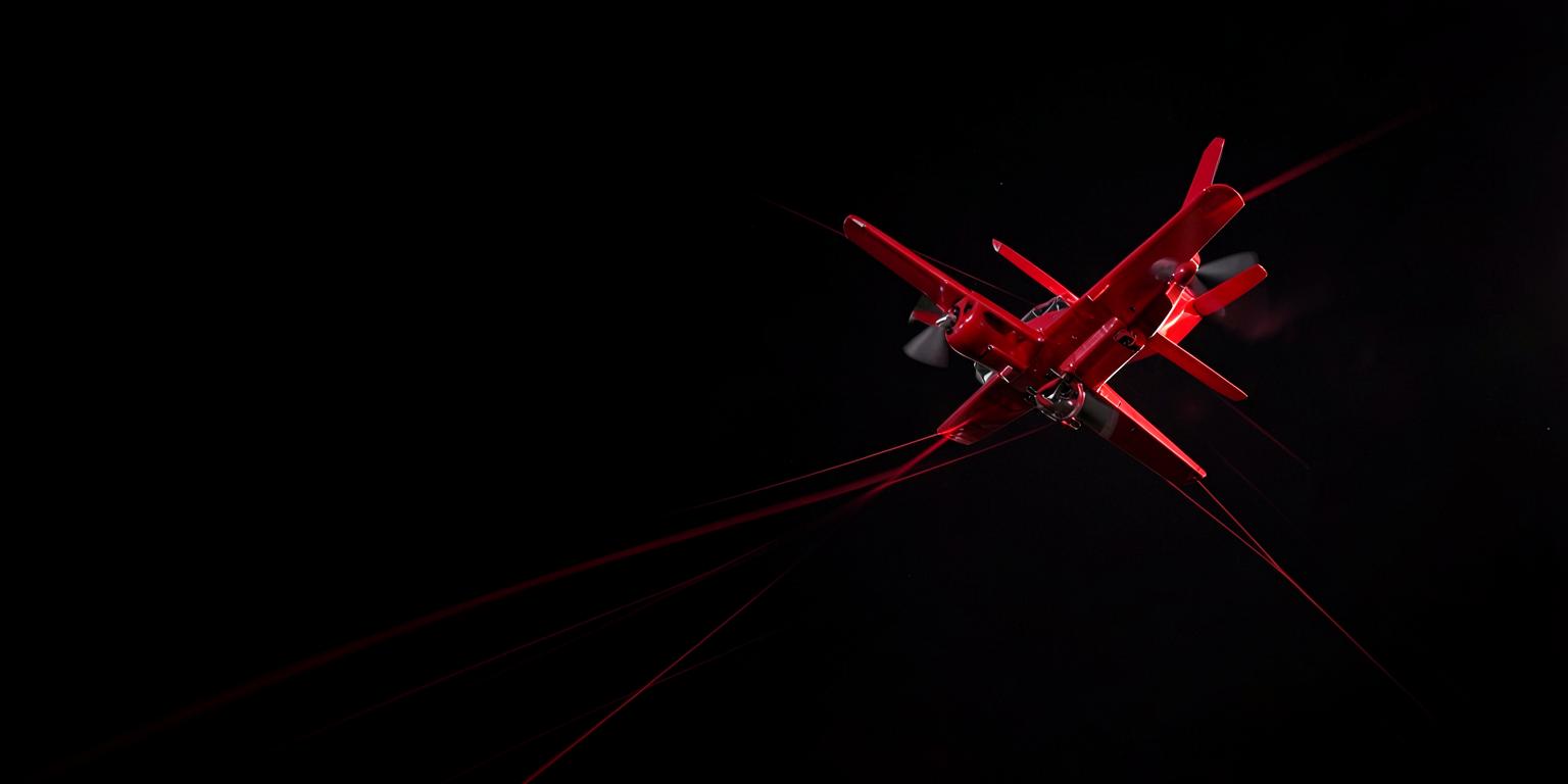 Red aircraft climbing through a dark sky